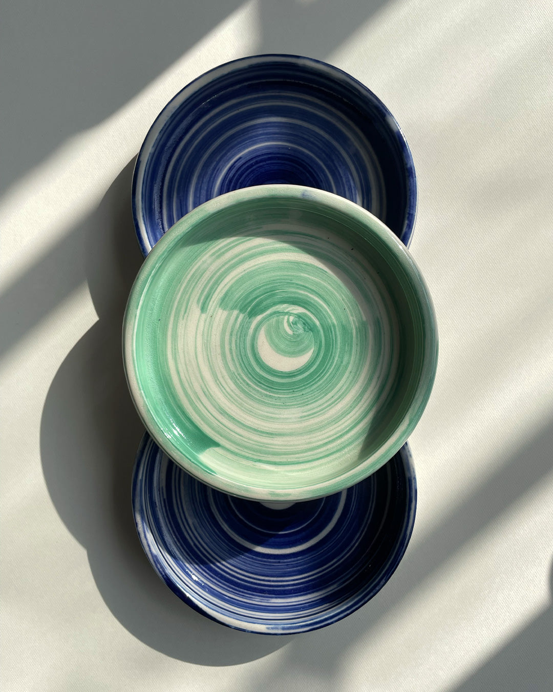 Tres postavasos, vista cenital. Pinceladas azul y verde.